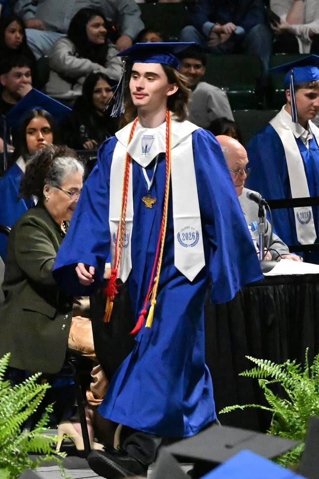 Jackson graduating high school in his blue cap and gown