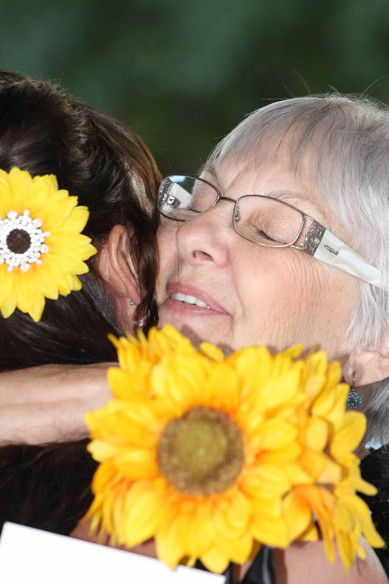 Mary Louise hugging her daughter Satin at Satin's wedding, surrounded by sunflowers